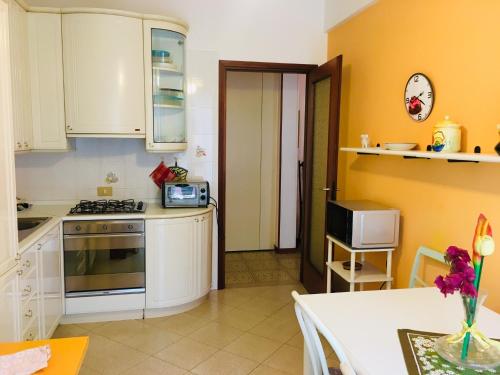cocina con armarios blancos y fogones en Appartamento Andora mare, en Andora