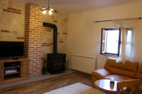 a living room with a couch and a stove at Mountain house Vilina rosa in Kolašin