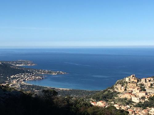 a view of a town and a body of water at Hotel de la Plage Santa Vittoria in Algajola