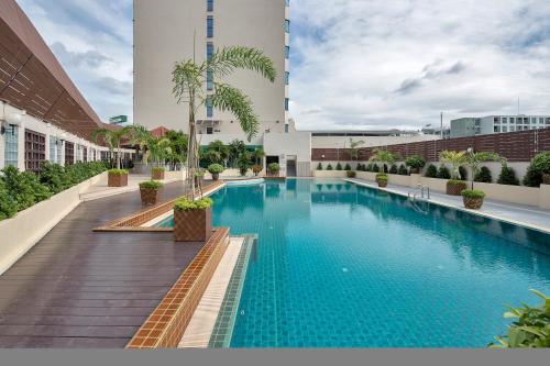 a large swimming pool in front of a large building at The Maruay Garden Hotel in Bangkok