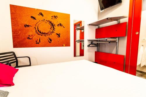 1 dormitorio con 1 cama y una pintura en la pared en ALIOCIO, en Palos de la Frontera