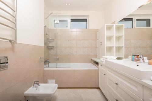 a bathroom with a sink and a tub and a toilet at Riviera Zoloche Resort & Spa in Vishenki