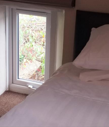 a bedroom with a bed and a window at The White House Guest House in Penrith