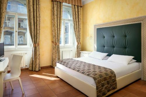 a hotel room with two beds and a window at Hotel Caesar Prague in Prague