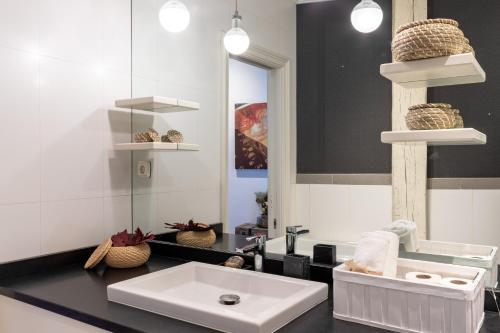 a bathroom with a white sink and a mirror at Confort y Diseño con Vistas al Casco Viejo in Bilbao