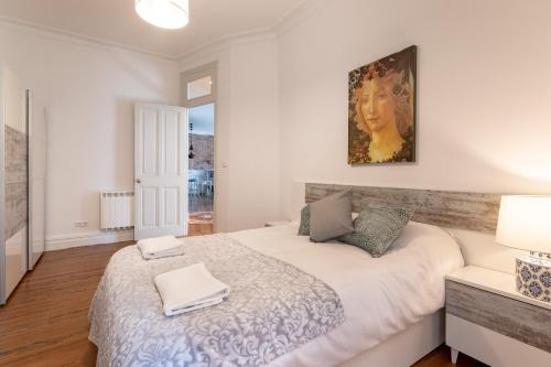 a bedroom with a large bed and a painting on the wall at Confort y Diseño con Vistas al Casco Viejo in Bilbao