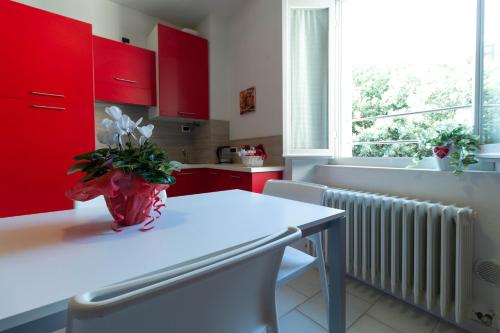 a kitchen with red cabinets and a vase of flowers on a table at Le Casette Di Osvaldo in Lecco