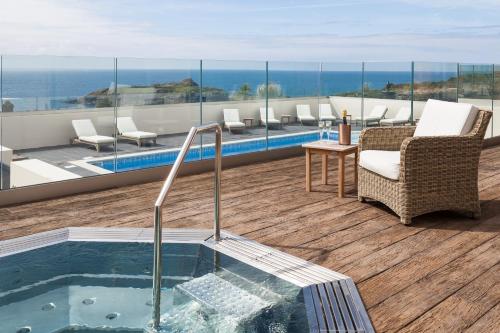 a hot tub in a room with a view of the ocean at Mullion Cove Hotel & Spa in Mullion