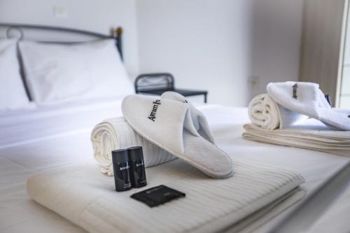 a pair of white shoes sitting on a bed at Francis Getaway in Pireaus in Piraeus