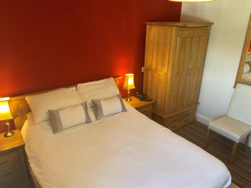 a bedroom with a white bed with two pillows at Boars Head Hotel in Carmarthen