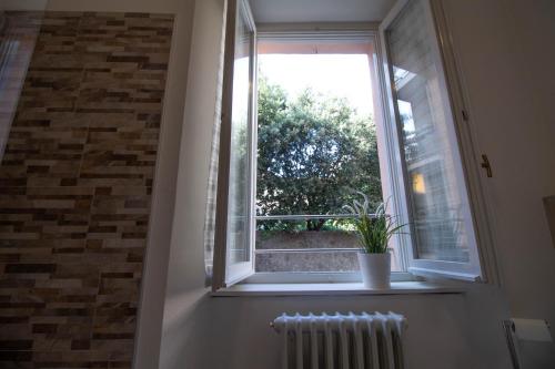 a window with a potted plant sitting on a window sill at Le Casette Di Osvaldo in Lecco