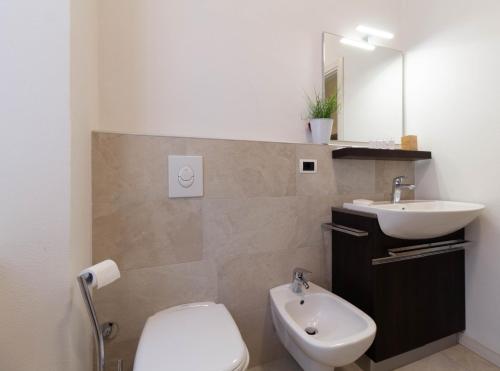 a bathroom with a sink and a toilet and a mirror at Le Casette Di Osvaldo in Lecco