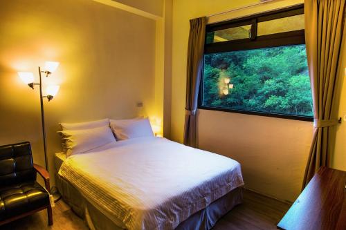 - une chambre avec un lit et une fenêtre dans l'établissement Antong Creekside Hot Spring, à Yuli