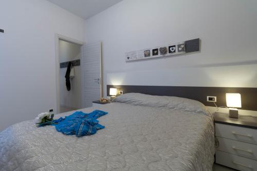 a bedroom with a bed with a blue shirt on it at Le Casette Di Osvaldo in Lecco