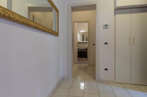 a hallway with white walls and a mirror on the wall at Le Casette Di Osvaldo in Lecco