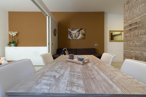 a dining room with a wooden table and white chairs at Le Casette Di Osvaldo in Lecco