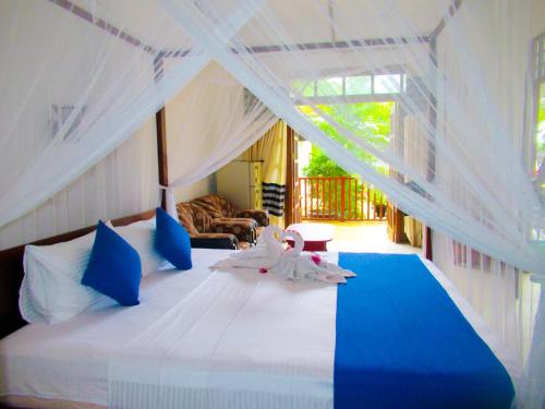 una camera da letto con un letto con due cigni sopra di Shanika Beach Inn a Tangalle