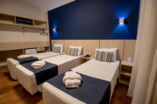 a room with three beds and a blue wall at Rio das Pedras Thermas Hotel in Caldas Novas