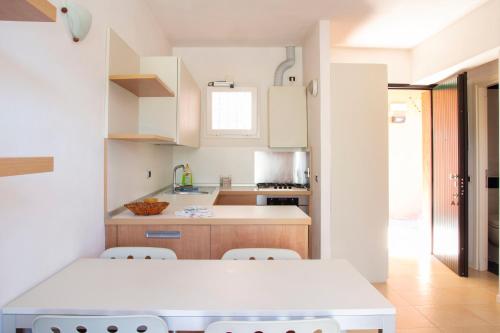 a white kitchen with a table and chairs at Allegroitalia Elba Golf in Portoferraio