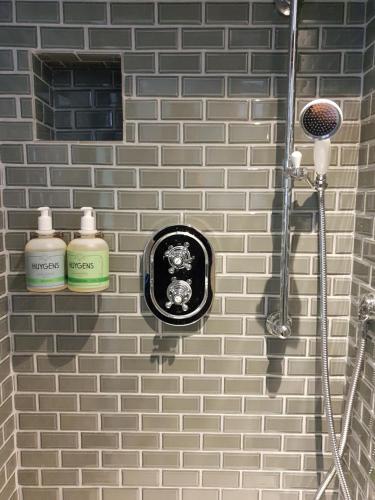 - une salle de bains avec 2 bouteilles sur un mur en briques dans l'établissement Domaine les Bruyères, à Gambais