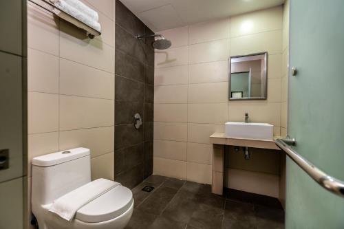 a bathroom with a toilet and a sink at Orange Hotel Kota Kemuning @ Shah Alam in Shah Alam