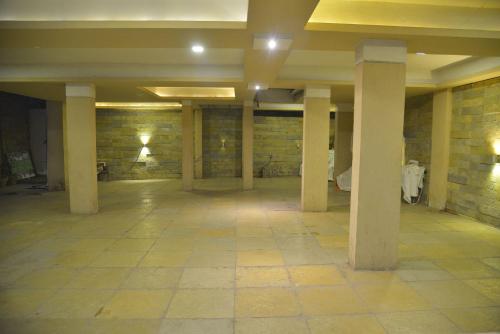 an empty room with columns and a brick wall at Pandharinath Lodge in Pandharpur
