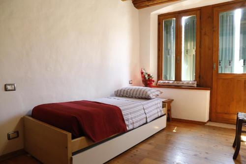 Un dormitorio con una cama en una habitación con ventana. en Luzzo 15, en Feltre
