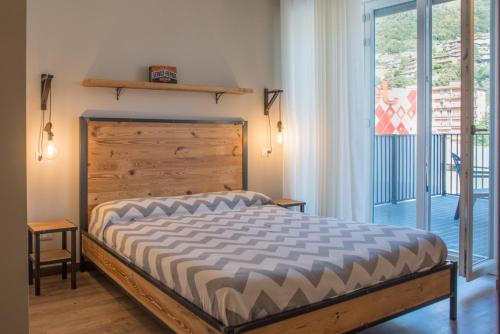 a bedroom with a bed with a wooden headboard and a window at Officina Rooms in Como