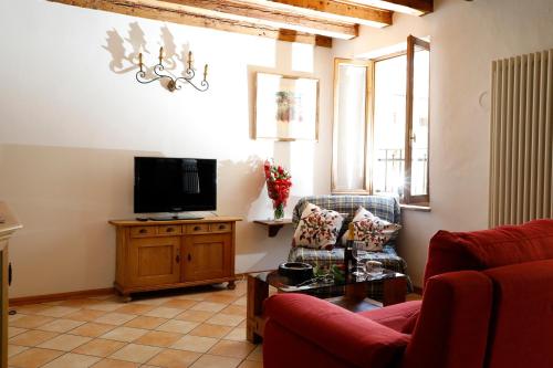 Una sala de estar con dos sillas y un televisor. en Luzzo 15, en Feltre