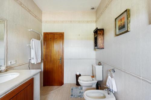 a bathroom with a toilet and a sink at Casa do Casal in Guimarães