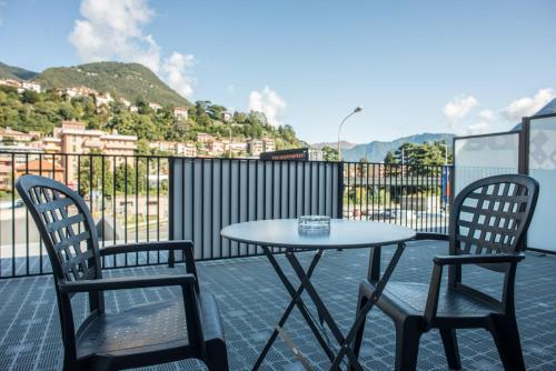 two chairs and a table on a balcony with a table at Officina Rooms in Como