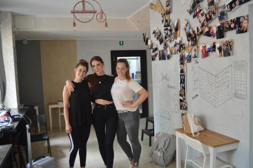 three women standing next to each other in a room at Lion University & Youth Hostel Milano in Milan