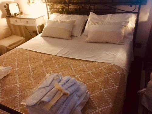 a bed with a cross and towels on it at Casa tipica siciliana patronale home BedandBreakfast TreMetriSoprailCielo Camere con vista, colazione interna in terrazzo panoramico in Caltagirone