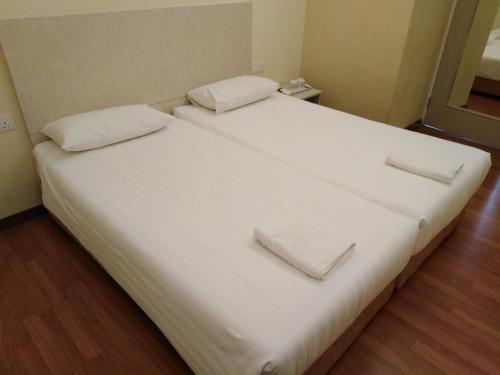 a large white bed with two white towels on it at 1ACS Residence in Kuching