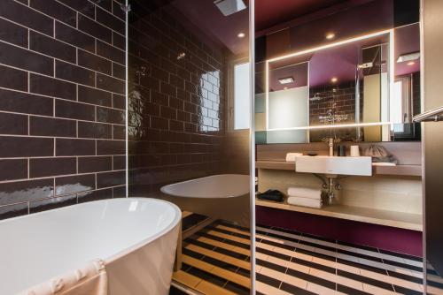 a bathroom with a tub and a sink at Ramble Hotel in Taichung