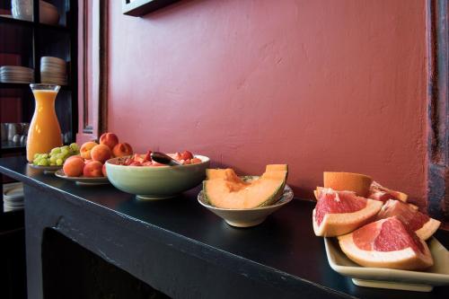 a table with bowls of fruit and plates of bread at Ganda Rooms & Suites in Ghent