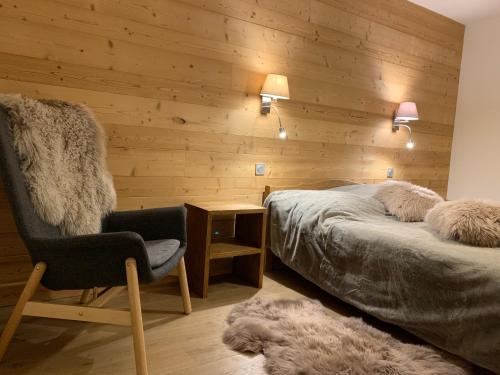 a bedroom with two beds and a chair and a rug at PORTES DU PLENEY 201 in Morzine