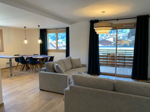 a living room with a couch and a table at PORTES DU PLENEY 201 in Morzine