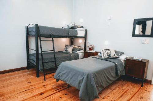 a bedroom with two bunk beds and a wooden floor at Milhouse Hostel Hipo in Buenos Aires