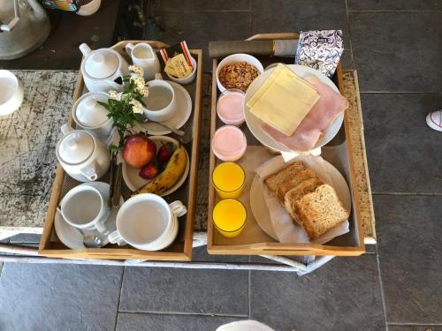 twee houten dienbladen met ontbijtproducten en drankjes erop. bij Resort 77 in Piriápolis