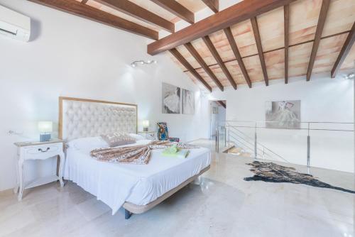 a bedroom with a large bed and a wooden ceiling at Can Brivo in Costitx