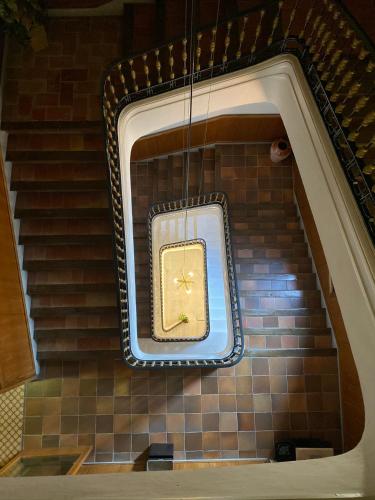 a gold clock on the side of a staircase at Hotel Suís in Sant Celoni