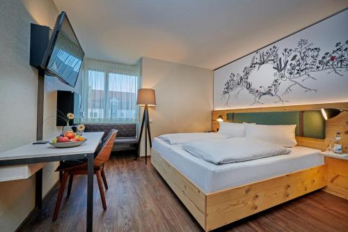 una habitación de hotel con una cama y una mesa con un bol de fruta en Ringhotel Gasthof Hasen, en Herrenberg