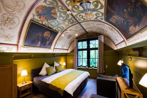 - une chambre avec un grand lit et un plafond orné de peintures dans l'établissement Ferienwohnung Burgkaiser, à Goslar