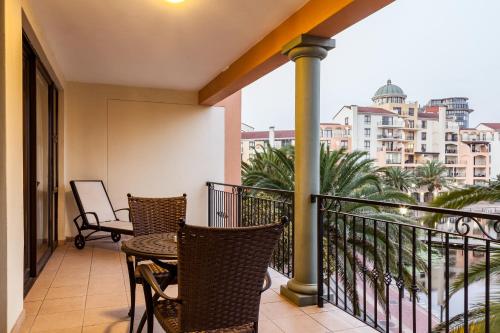 a balcony with chairs and a table on a balcony at Island Club Hotel & Apartments in Cape Town