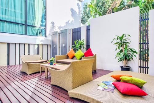 a lobby with chairs and tables and plants at Mida Hotel Ngamwongwan - SHA Plus in Nonthaburi