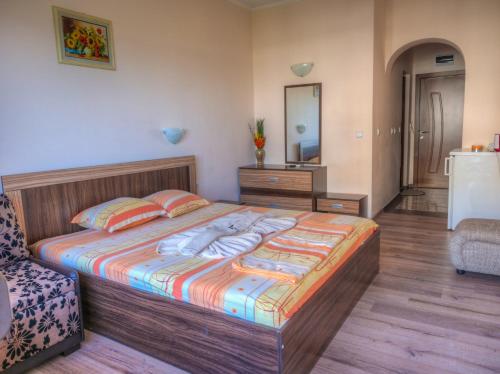 a bedroom with a large bed and a mirror at Hotel Fantasy Beach in Sveti Vlas