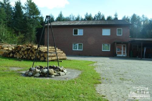 a pile of logs in front of a building at Gästehaus Zimmer Frei in Bramstedt