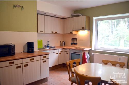 a kitchen with white cabinets and a table and a window at Gästehaus Zimmer Frei in Bramstedt