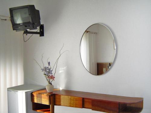 a room with a mirror and a tv on a wall at Hotel Morales in San Clemente del Tuyú